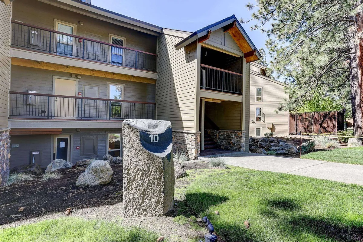 This exterior image captures the entrance to the building surrounded by landscaped greenery and a welcoming stone marker. The lush landscaping and visible pathway evoke a sense of arrival and easy access to resort amenities, making it a perfect representation of the convenience and family-friendly environment described in the section.